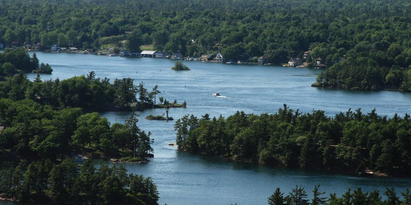 An aerial view shows the many lush green islands and blue water channels that make up the Thousand Islands Conservation Area.