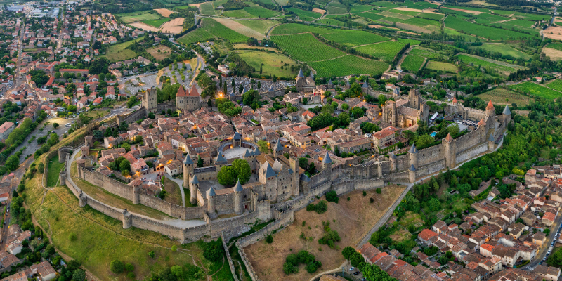 An aerial view of Carcassonne reveals its medieval architecture and lush greenery, making it a must-visit tourist attraction in France.