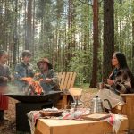 A joyful family sitting by a campfire in Ocala National Forest, creating memories and enjoying each other's company.