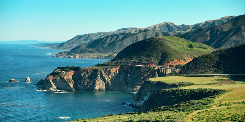 Scenic view of Big Sur, showcasing the ocean and mountains from a picturesque hilltop.