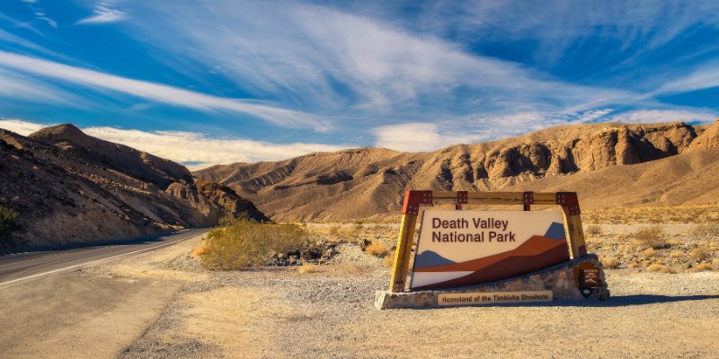 The breathtaking landscape of Death Valley National Park features its iconic dunes and rugged mountains under a clear sky.