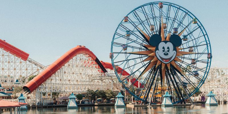 A vibrant Disneyland scene featuring a colorful Ferris wheel alongside a thrilling roller coaster.