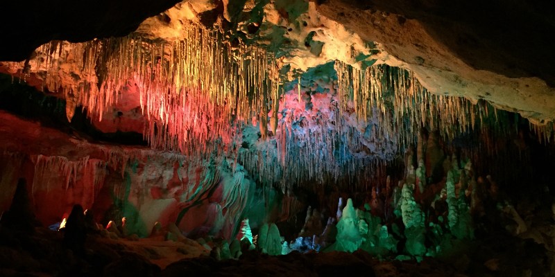 A mystical cave adorned with brilliant rainbow colors, creating a captivating and colorful atmosphere within.