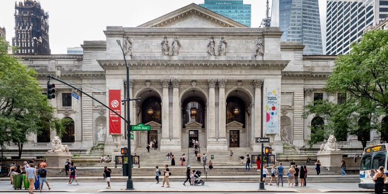 A grand view of the New York Public Library, showcasing its iconic architecture and bustling surroundings.