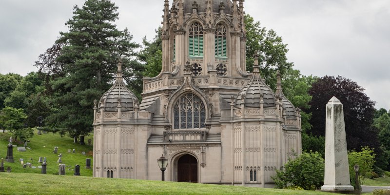 A gothic-style church is centrally located within a cemetery, framed by gravestones and an air of tranquility.