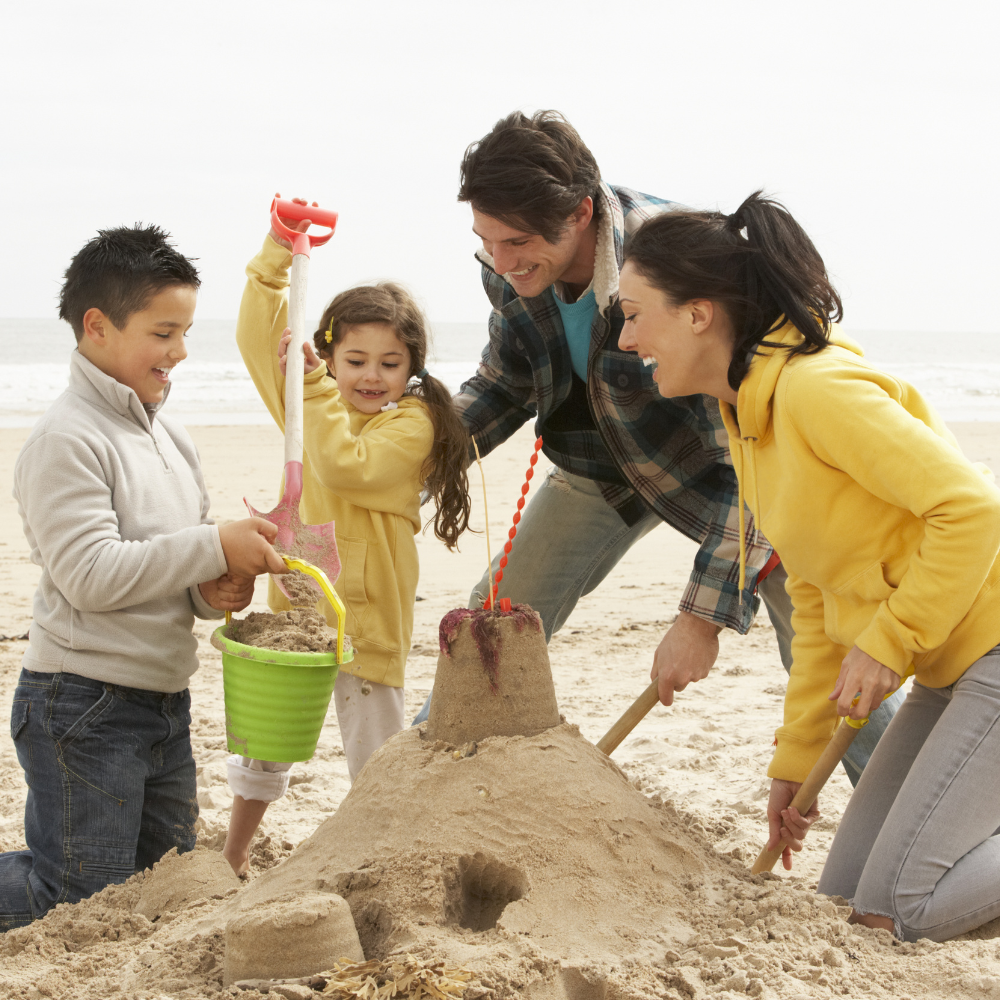 A family happily building a sandcastle on a tranquil beach, enjoying the natural beauty of Florida’s Gulf Coast.