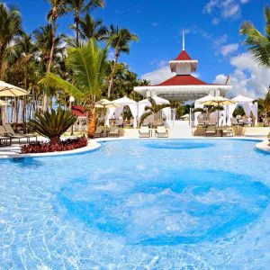 A spacious pool surrounded by lounge chairs and colorful umbrellas, perfect for relaxation and sunny days.