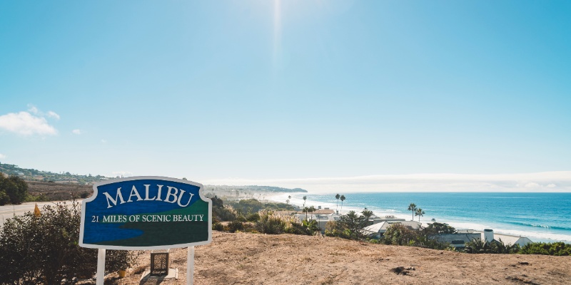 A beautiful Malibu beach landscape with a photographer capturing the essence of the sun and surf.