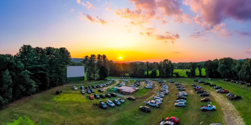 Overhead shot of a car park at Mission Tiki Drive-In Theatre with a prominent movie screen.