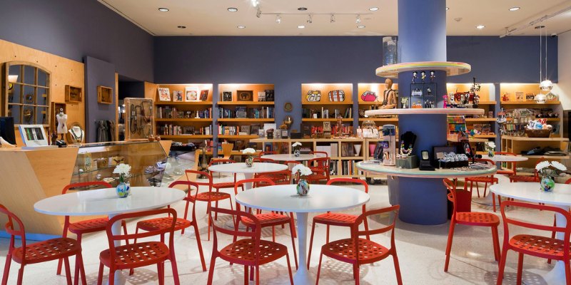 Interior view of NSU Art Museum showcasing red chairs and tables, enhancing the cheerful ambiance for guests.