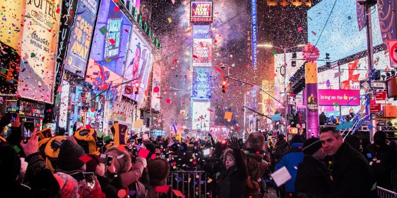 Crowds gather in Times Square, New York City, to celebrate New Year's Eve with lights, confetti, and the iconic ball drop.