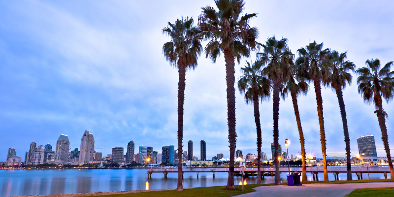 San Diego skyline illuminated at dusk, showcasing vibrant colors and city lights against a twilight sky.