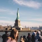 View of the Statue of Liberty from the water, showcasing its iconic silhouette against the skyline.