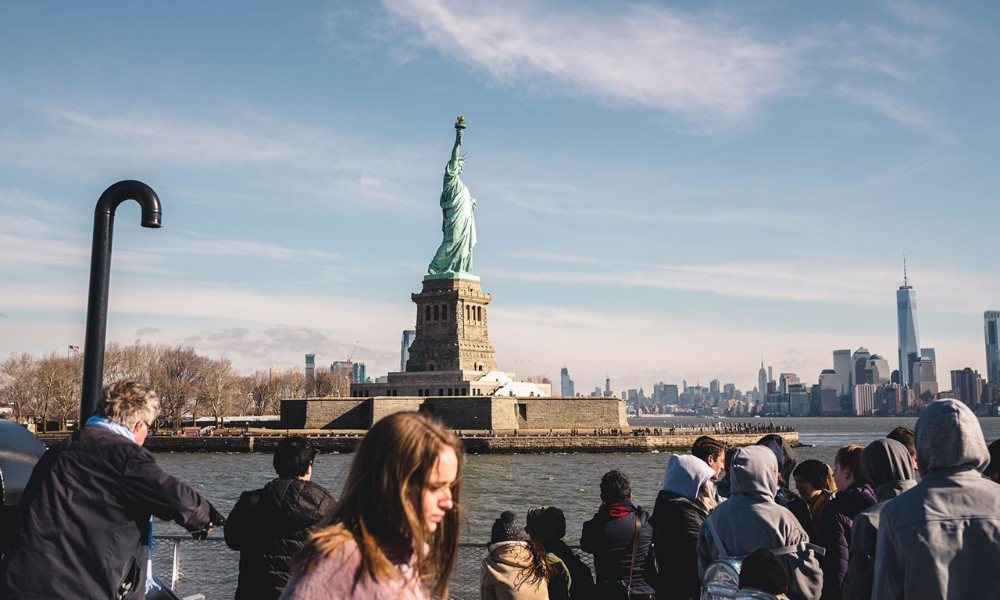 View of the Statue of Liberty from the water, showcasing its iconic silhouette against the skyline.