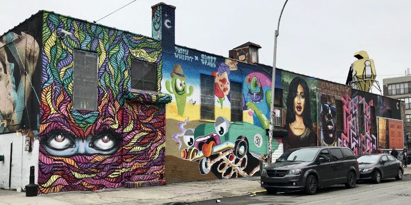 A vibrant mural adorns a building in Bushwick, showcasing colorful street art that enhances the urban landscape.