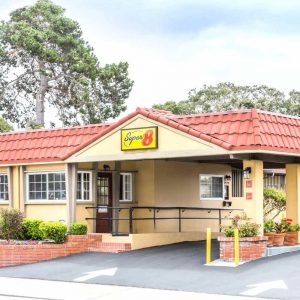 A charming motel featuring a bright yellow roof and a classic red tiled roof, inviting guests to enjoy their stay.