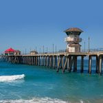 Huntington Beach Pier with ocean waves and a clear blue sky, is one of the top things to do in California near Disneyland.