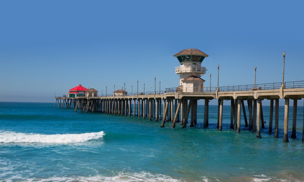 Huntington Beach Pier with ocean waves and a clear blue sky, is one of the top things to do in California near Disneyland.