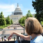 A woman on a bus, deep in thought about traveling during the U.S. election period.