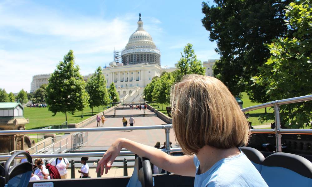 A woman on a bus, deep in thought about traveling during the U.S. election period.