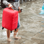 A traveler holding his luggage due to flood water in Valencia Spain.