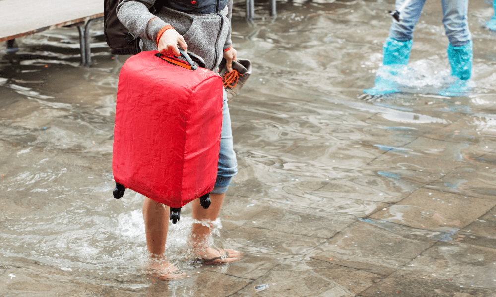 A traveler holding his luggage due to flood water in Valencia Spain.