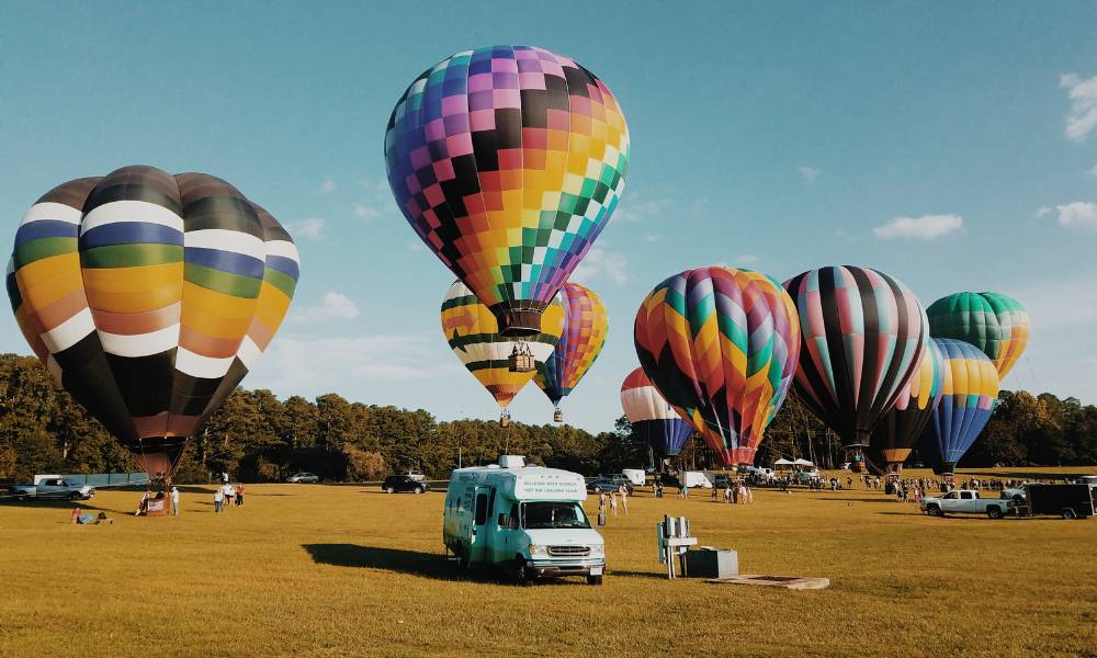 A lively scene of colorful hot air balloons getting ready to take off in a grassy field highlights one of the best things to do in Central Florida.