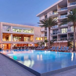 A serene view of the pool at the Westin Miami Beach, surrounded by lush palm trees.