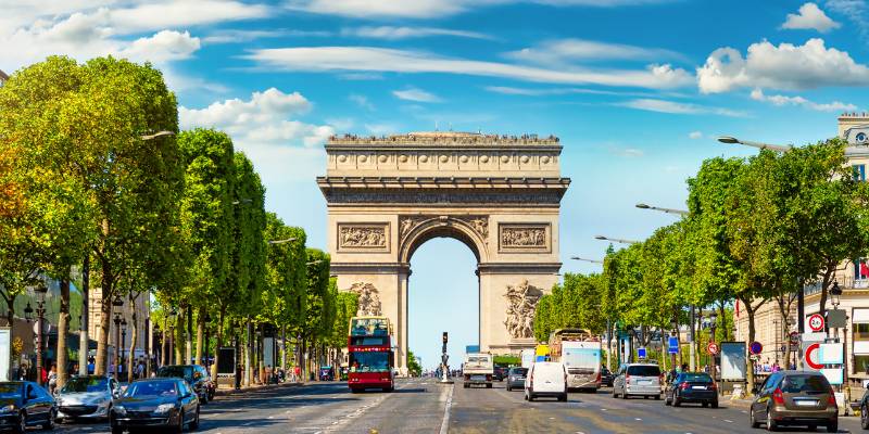 The Arc de Triomphe stands majestically in Paris, France, surrounded by bustling streets and vibrant city life