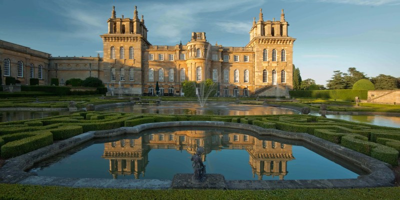 The magnificent Blenheim Palace is beautifully set amidst a flourishing garden, showcasing its grandeur.