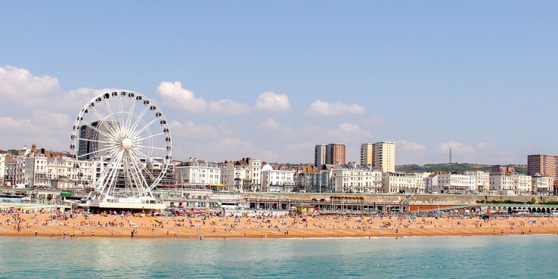 Brighton Beach features the famous pier, with sunlit sands and lively beachgoers enjoying the coastal atmosphere.