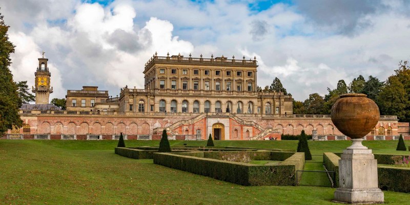 A grand view of Cliveden House, showcasing its impressive architecture and expansive garden in the foreground.