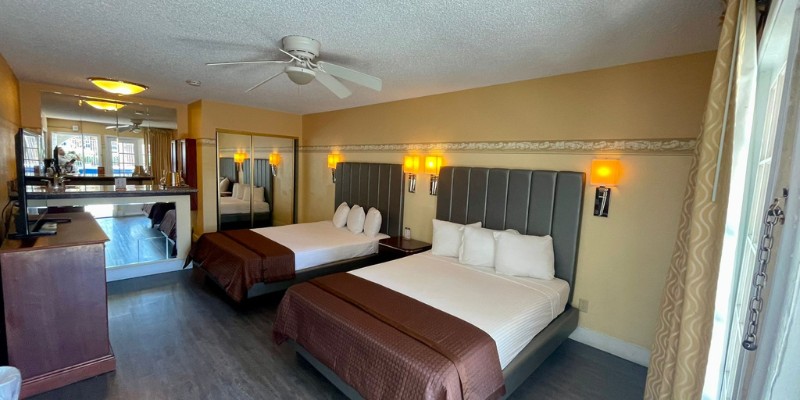 Spacious Deluxe Family Suite showcasing two beds, a television, and a refrigerator for a comfortable stay.