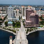 Palm Beach city skyline showcasing impressive tall buildings and a scenic bridge under a bright sky.