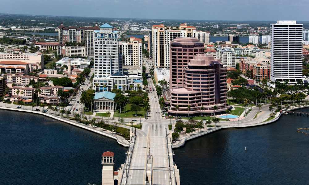 Palm Beach city skyline showcasing impressive tall buildings and a scenic bridge under a bright sky.