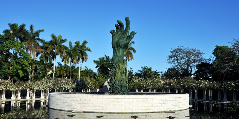 The Holocaust Memorial features a striking hand statue emerging from a serene pond, evoking deep reflection and remembrance.