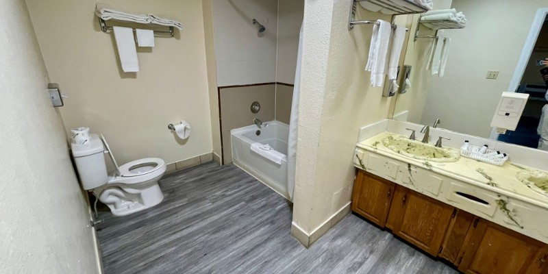 A stylish hotel bathroom showcasing a toilet, sink, and bathtub, designed for comfort and convenience.