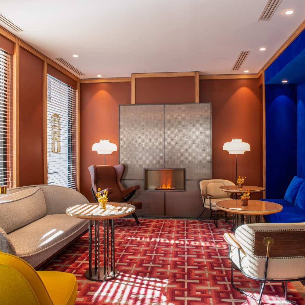 Hotel Yllen Eiffel's contemporary lobby, adorned with blue walls and bold red accents, offering a warm and inviting space.