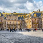 A view of the Palace of Versailles, highlighting its opulent design and beautifully manicured gardens in France.