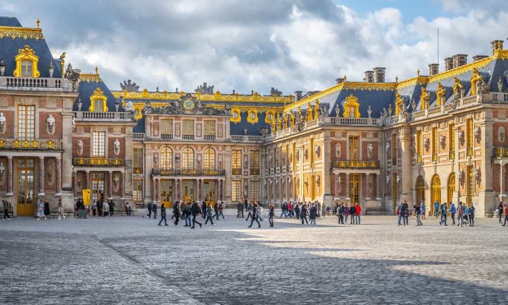 A view of the Palace of Versailles, highlighting its opulent design and beautifully manicured gardens in France.