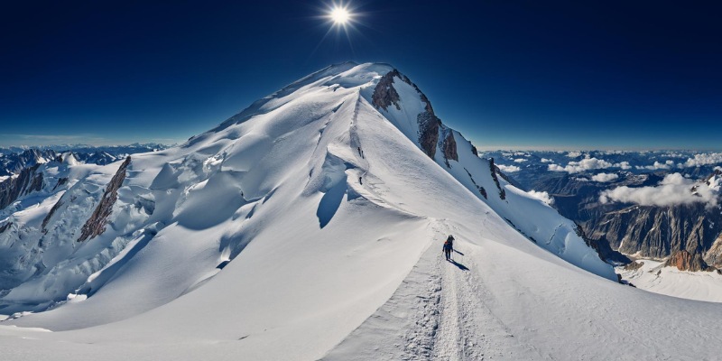 A man treks up the snow-covered Mont Blanc, highlighting the challenges and beauty of mountain exploration.