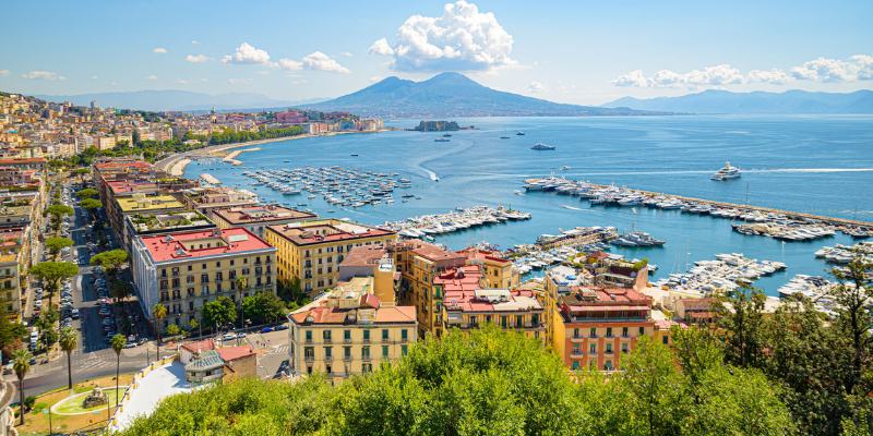 An aerial perspective of Naples, Italy, featuring its colorful streets and breathtaking waterfront.