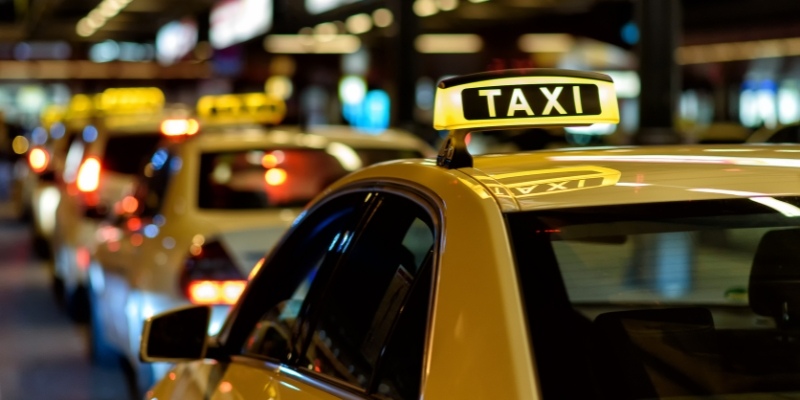 Nighttime cityscape featuring bright taxi cabs, highlighting the importance of public transportation in urban life.