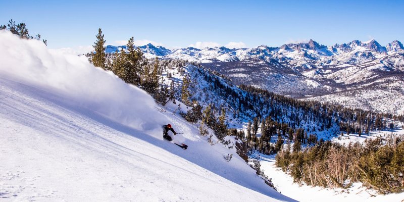 A person skillfully skis down a snowy mountain, enjoying the thrill of the winter landscape around them.