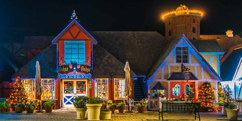 Nighttime in Solvang, featuring a cozy Christmas house surrounded by twinkling lights in a quaint small town.