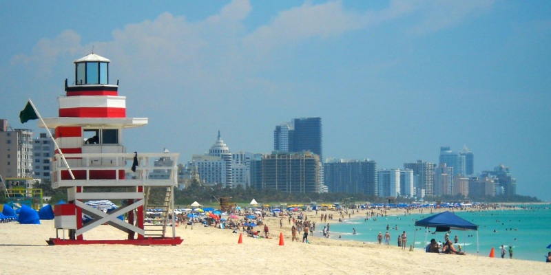 South Beach features a lifeguard tower with beachgoers relaxing on the sandy shore.