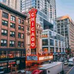 A lively Chicago city street scene featuring cars and impressive buildings lining the background.