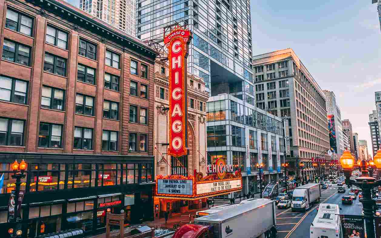 A lively Chicago city street scene featuring cars and impressive buildings lining the background.