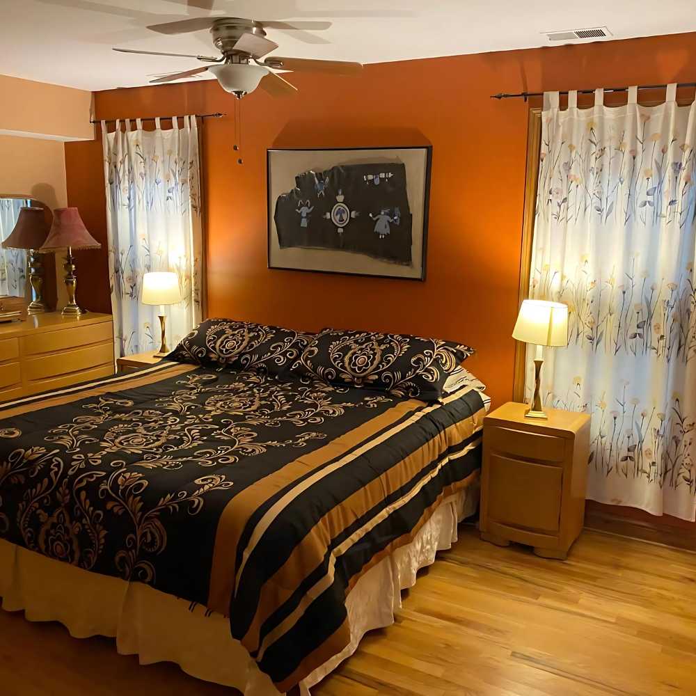 A spacious hotel room at Superior 1467, showcasing a large bed and a modern dresser for a comfortable retreat.