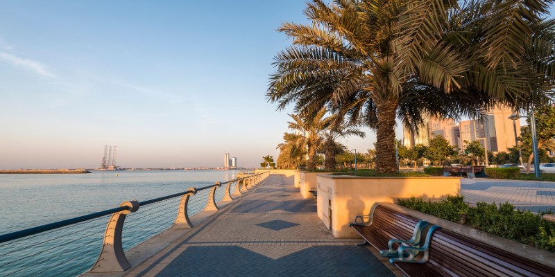 A tranquil bench facing the water, providing a scenic view of the cityscape at The Corniches.